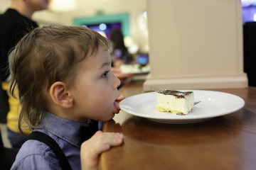 Kid licking plate with cake
