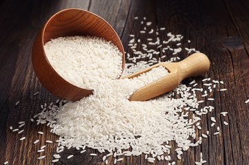 Rice in bowl and scattered near - obrazy, fototapety, plakaty