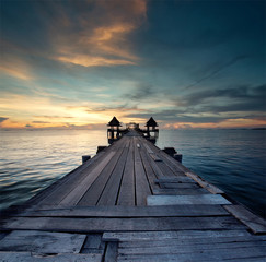 Naklejka na ściany i meble The long bridge over the sea with a beautiful sunrise, Thailand