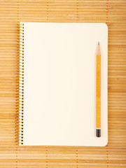 Notebook on natural bamboo textured background