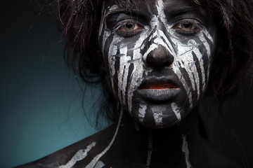dark portrait of woman in black paint with white smudges 