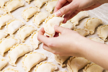 Dumplings. Dough with illing on the cook's hands.