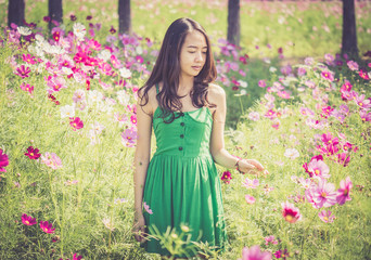 Asian woman smelling a cosmos flower, Retro filter effect added