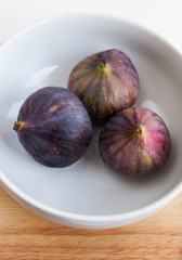 Top view of three ripe figs in the bowl
