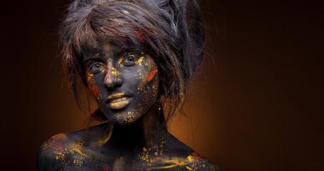 dark portrait of woman in black paint with yellow smudges