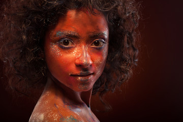 young woman with creative red  face-art and afro hair
