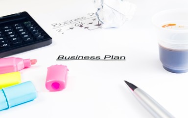 business plan words near highlighters, calculator and coffee