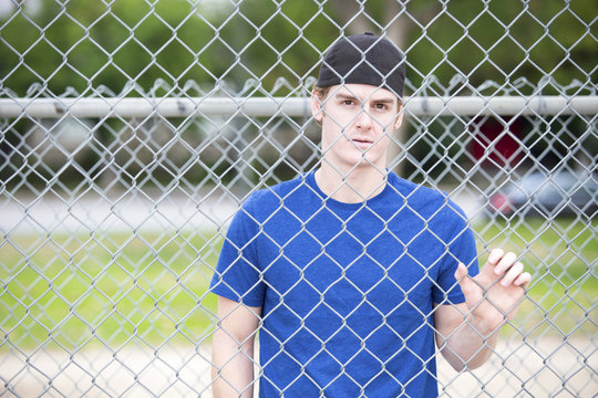 Young Man Behind A Fence