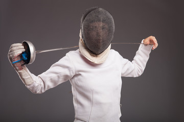 girl in white fencing costume. with sword and  fencing mask 