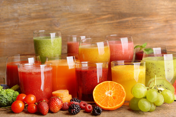 Glasses of tasty fresh juice, on wooden table.