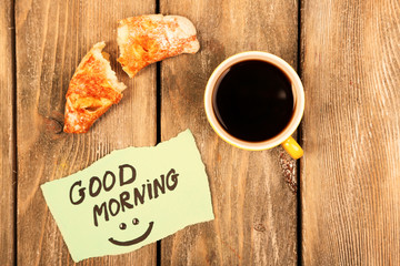 Composition of coffee, fresh croissant and paper card