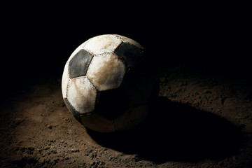 Soccer ball on ground on dark background