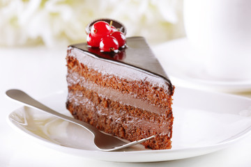 Delicious chocolate cake on plate on table on light background