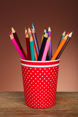 Colorful pencils in red plastic cup