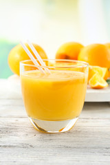 Glass of orange juice with straw and slices