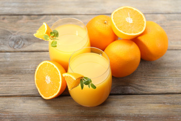 Glass of orange juice and slices on wooden table background