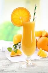 Glass of orange juice with straw and slices
