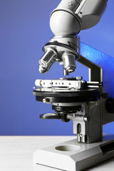 Microscope on blue background, close-up