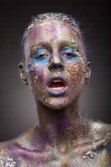 Beautiful face of a woman covered in glitter. Face art. Sexy