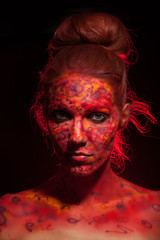Fashion Model Portrait with red face art. Body art.Paint on face