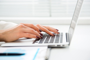 Fototapeta na wymiar Closeup of businesswoman typing on laptop computer