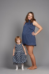 young girl hug pregnant mother