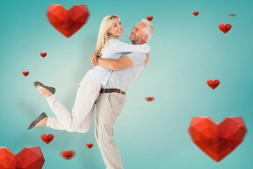 Composite image of man picking up his partner while hugging here