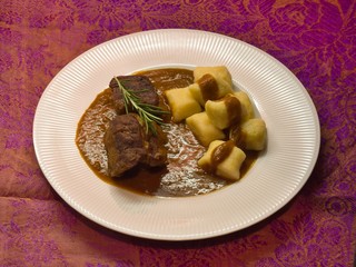 Roasted wild game in ginger bread sauce with potato dumplings