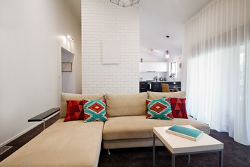 Modern living room sofa with kitchen in background