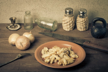 Onion, roasted potato, knive, salt, pepper and other things on t