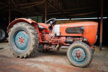 Oldtimer - alter Güldner Traktor steht vor einer Scheune