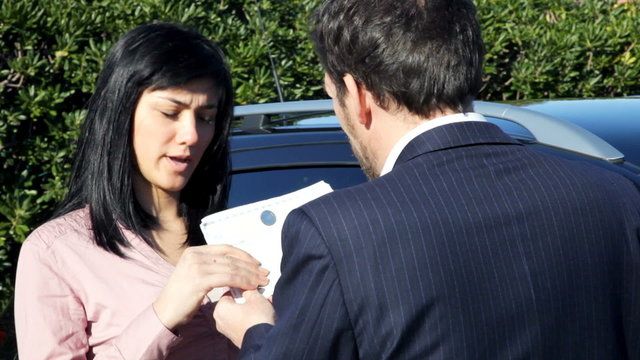 Salesman giving document and keys of new car