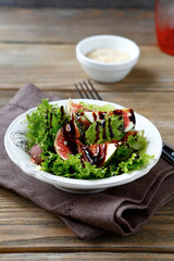 Light salad with figs, lettuce and balsamic sauce in a bowl