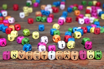 Sign INVESTIGATION and many wooden cubes with letters