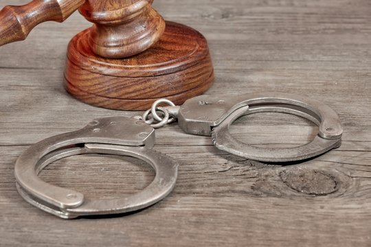 Handcuffs and Gavel in Courtroom