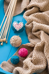 Wooden needles lie next to the bright tangle of threads
