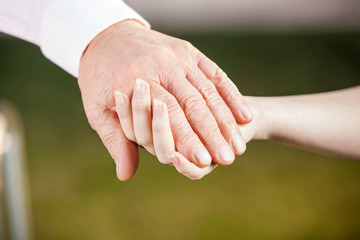 Nurse Holding Senior Man's Hand