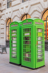 Fototapeta na wymiar Green painted phone boxes in London city.
