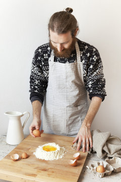bearded stylish man with apron making dough for fresh pasta