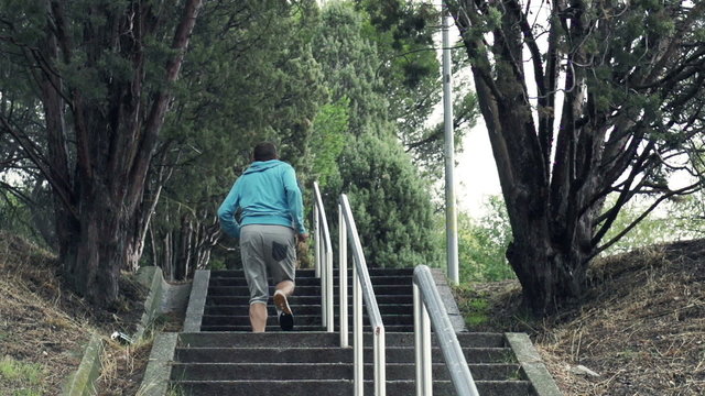 Man jogging up the stairs in park,
