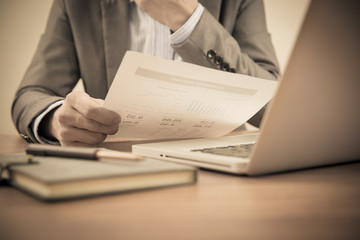 Businessman analyzing investment charts with laptop. Accounting