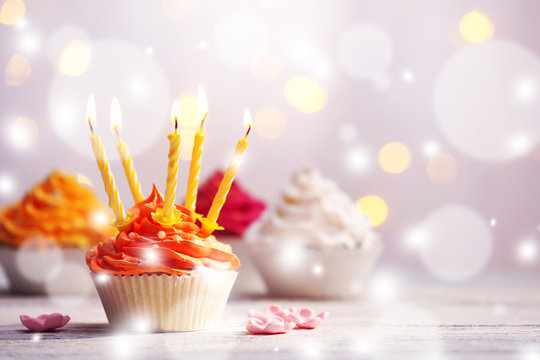 Delicious birthday cupcakes on table on light festive