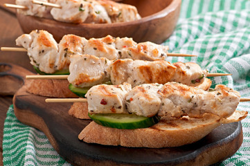 Chicken kebabs on skewers with toast
