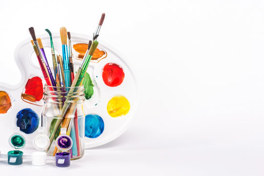 isolated water paint and paints brushes in a glass