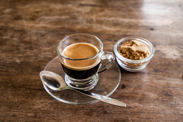 Cup of hot espresso coffee on wooden table.
