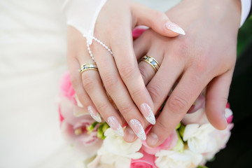 Hands of the groom and the bride with wedding rings - 75762325