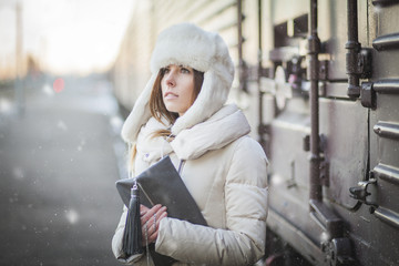 Pretty girl in winter blizzard on railroad station