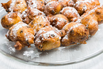 Sugared fryed fritters with raisins on glass scale
