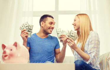 couple with money and piggybank ot table at home