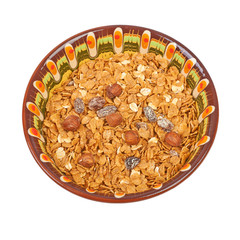 Bowl of oatmeall with fruit on a plate, isolated on white